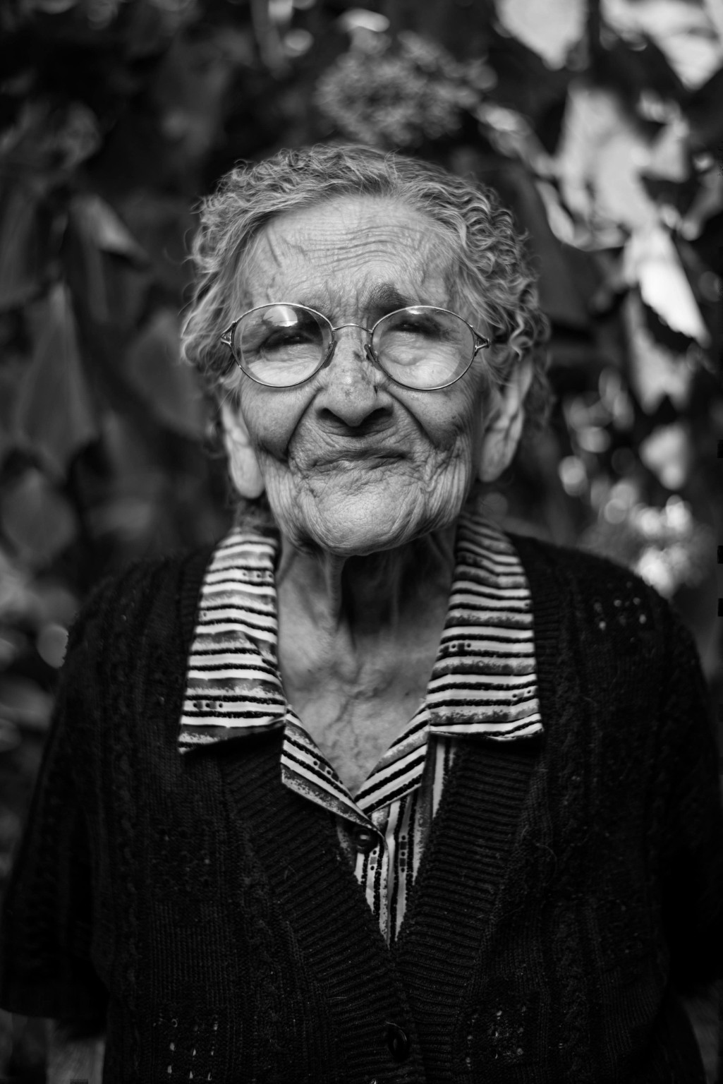 An older woman wearing glasses, photographed outdoors